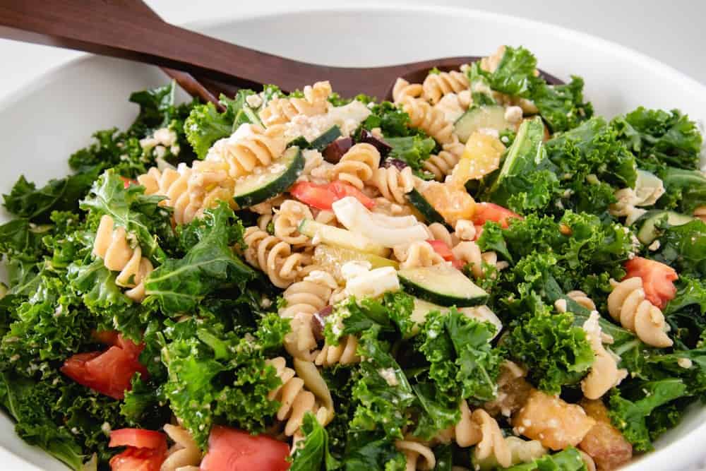 This easy kale salad recipe is a great clean out the fridge meal! It's full of healthy ingredients, with a super simple balsamic dressing to top it off. Enjoy this simple summer salad with your family today! #healthyrecipes #healthykalesalad