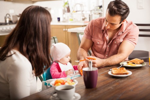 Parents eating breakfast with baby girl