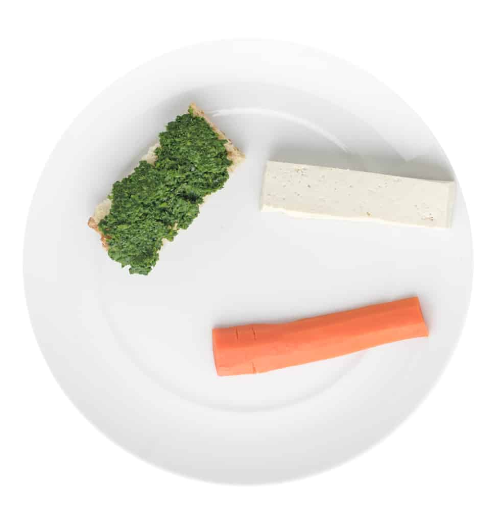Plate with kale pesto on finger of bread, finger of tofu and a finger of carrot
