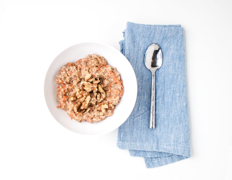 Bowl of carrot cake oatmeal with a spoon next to it