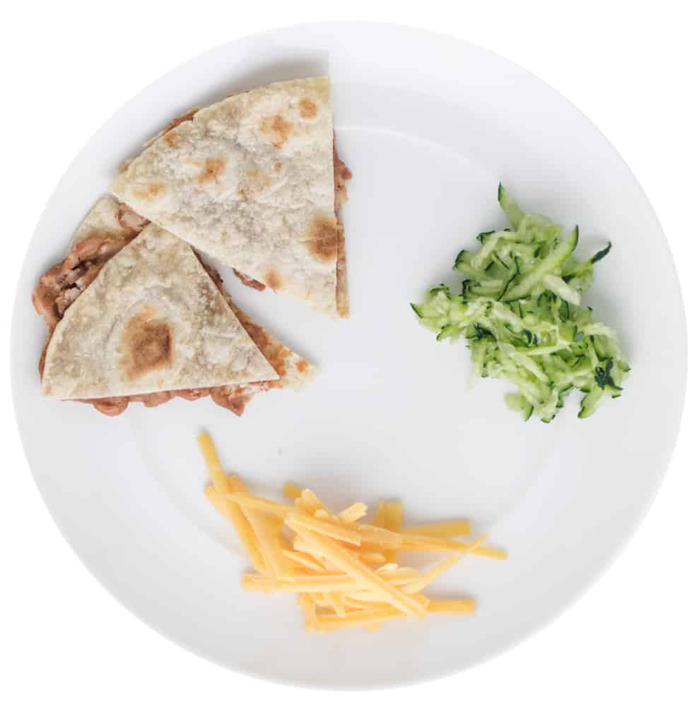 Mashed pinto bean quesadilla with cheese and cucumbers