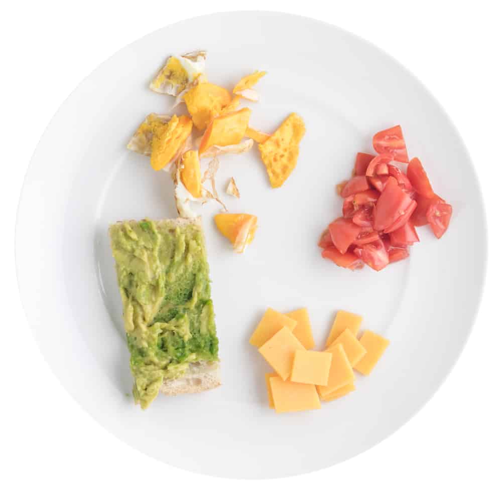 Fried egg sandwich with avocado toast, cheese, tomatoes