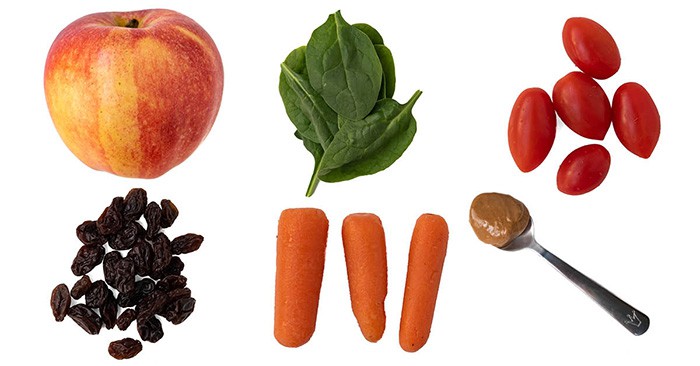 Picture of apple, spinach, cherry tomatoes, raisins, carrots, and peanut butter on a spoon