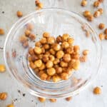 close up of roasted chickpeas in glass bowl on sheet pan